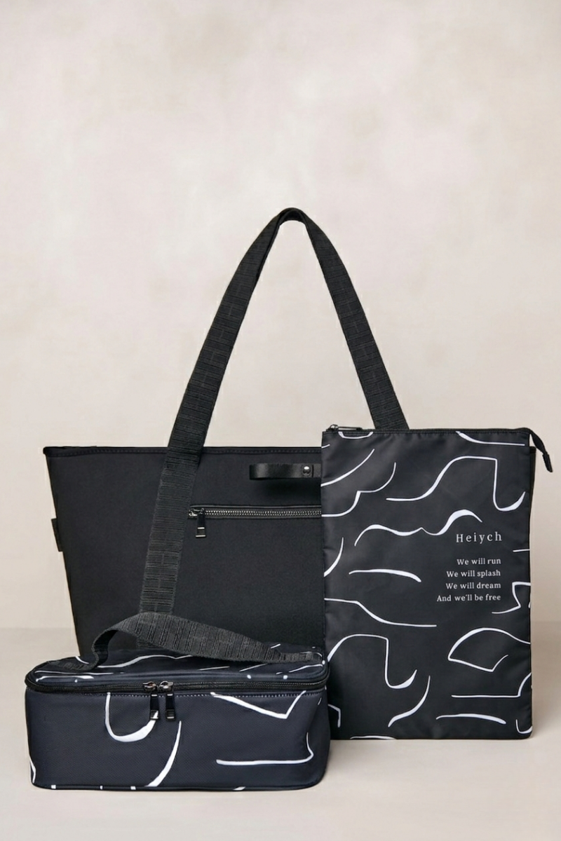 Black tote bag with patterned pouches on a beige background