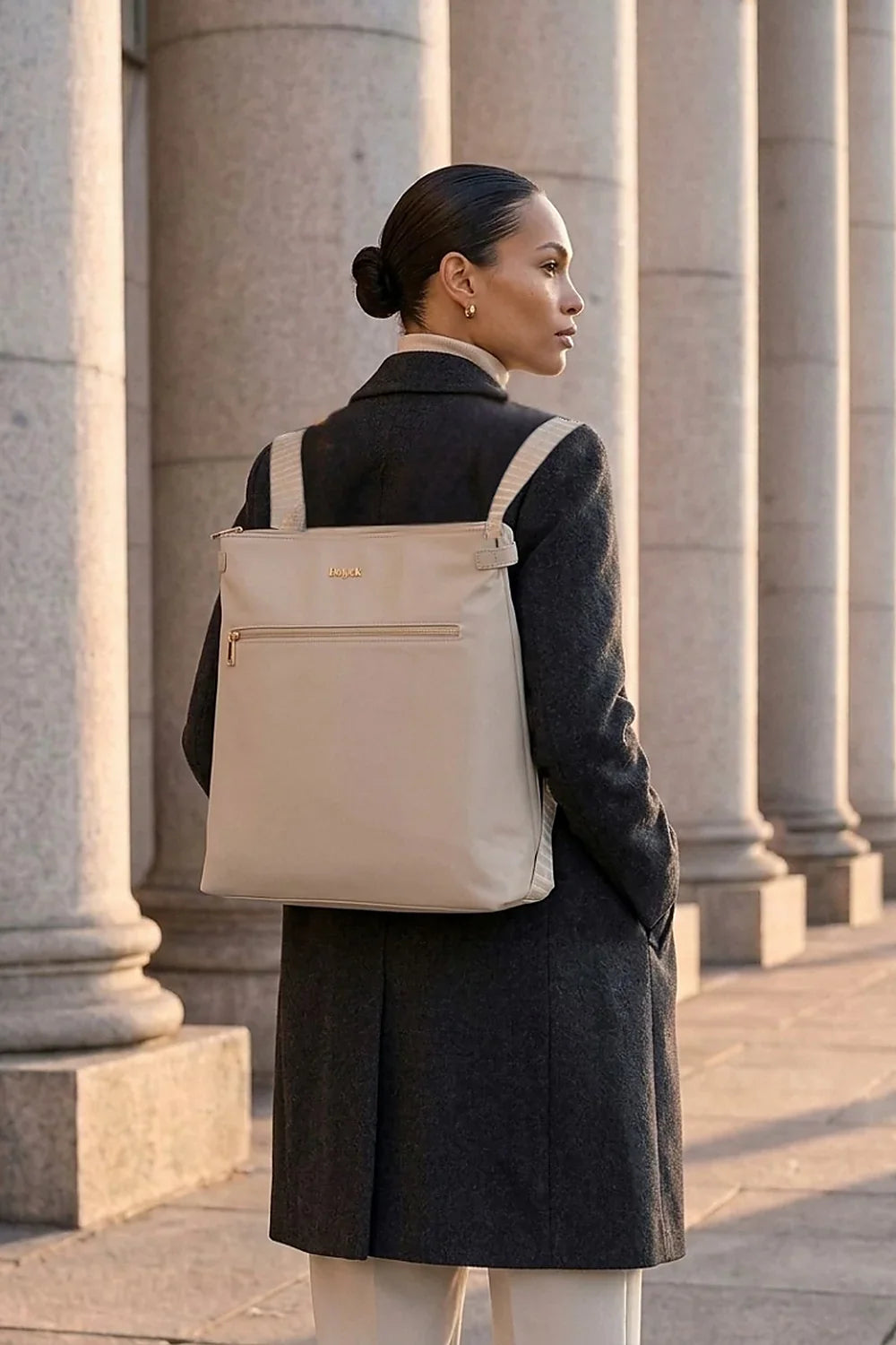 Woman wearing a taupe Heiych convertible tote backpack