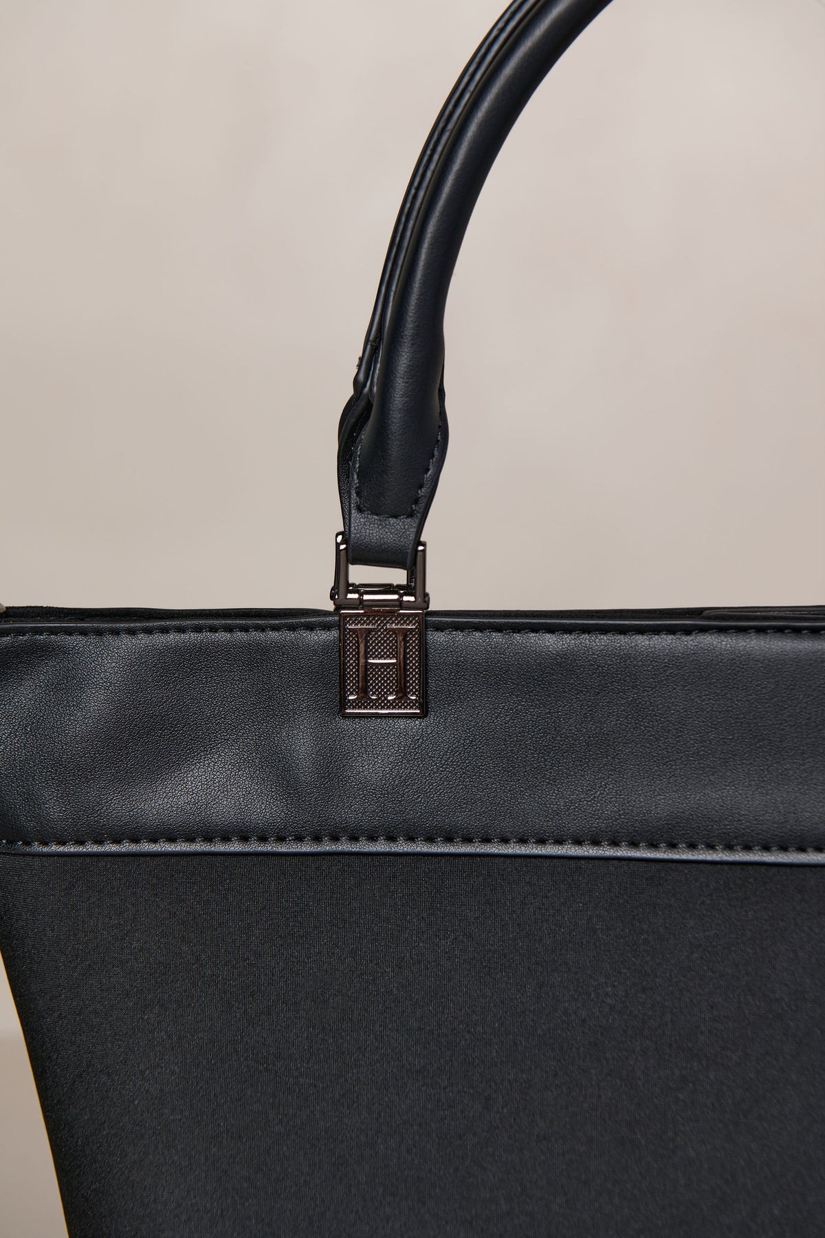 Black neoprene crossbody tote bag with handle and adjustable strap with gunmetal hardware