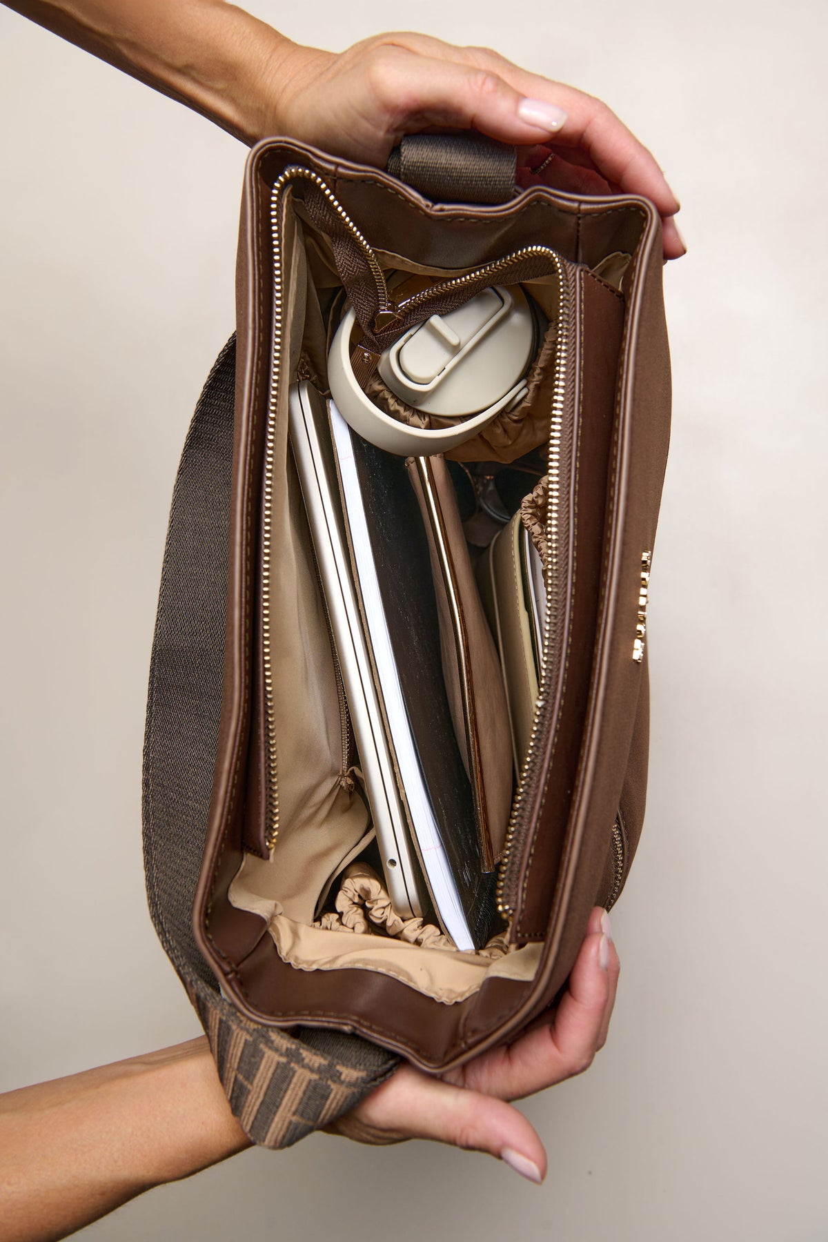 Chocolate brown convertible tote backpack bag in neoprene with gold hardware filled with laptop drink bottle